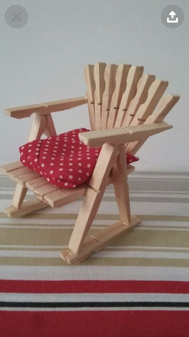 a wooden rocking chair with red and white polka dot pillow on it's seat