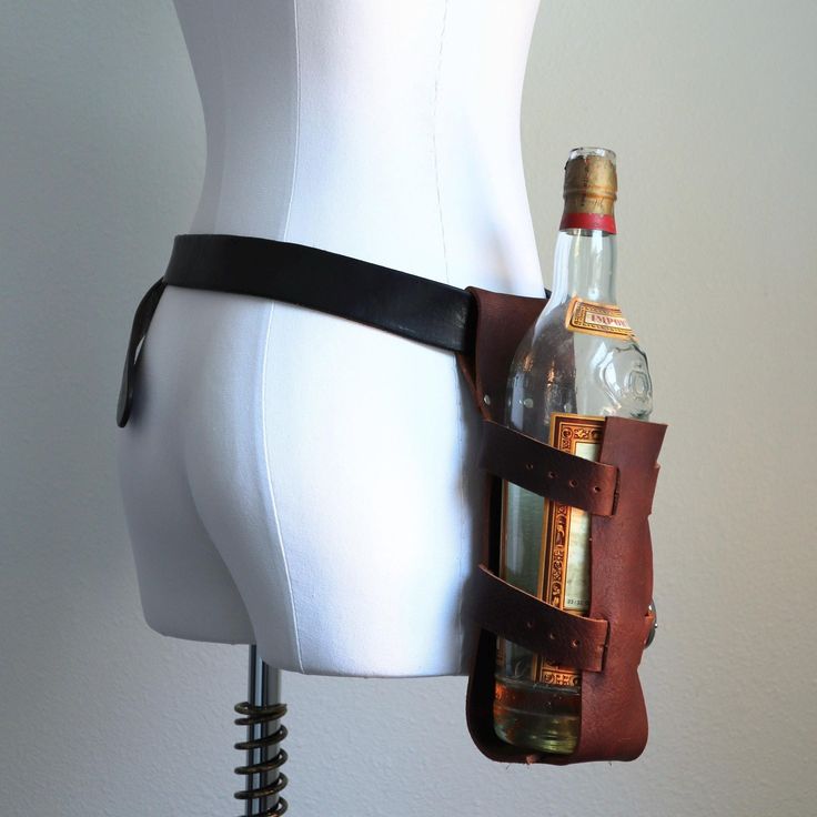 Everyone wishes they could carry their bottle full of choice delicious drink, be it alcoholic or not, but often don't want the arduous task of carrying it in their hands. You need not have this worry anymore! Holster your tasty beverage at your side and be ready for a quick draw quaffing at anytime.  This cowhide leather holster is adjustable and will fit many different sizes of bottles and comes in a few color choices. Adjusts with two buckles Simply slides onto a belt Belt not included Leather Bottle Holder, Post Apocalyptic Clothing, Apocalyptic Clothing, Leather Headbands, Quick Draw, Steampunk Clothing, Purse Strap, Bottle Holder, Support Handmade