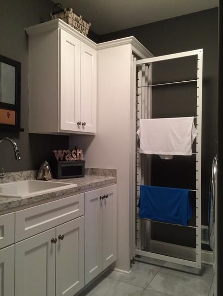 a bathroom with white cabinets and blue towels hanging on the rack above the sink area