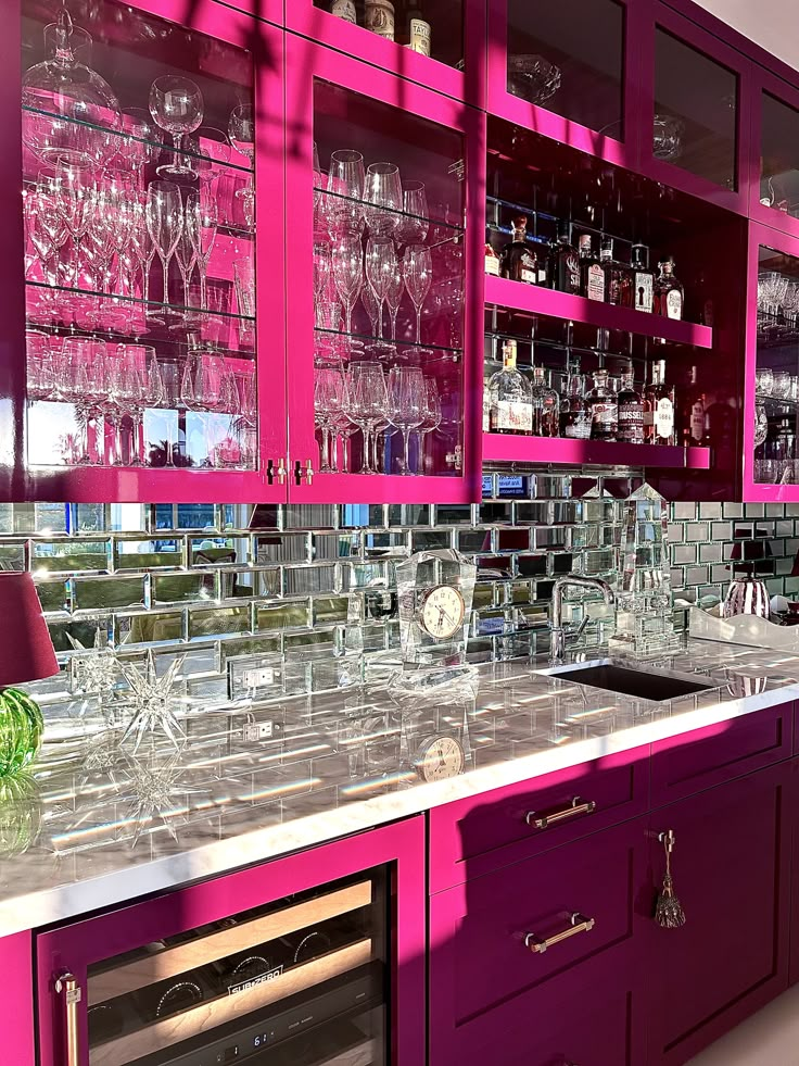 a kitchen with purple cabinets and wine glasses