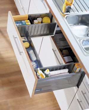 an open drawer in a kitchen next to a sink