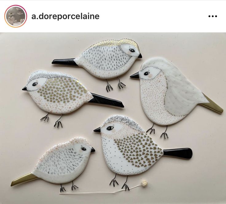 three white birds sitting on top of each other in front of a wall mounted mirror