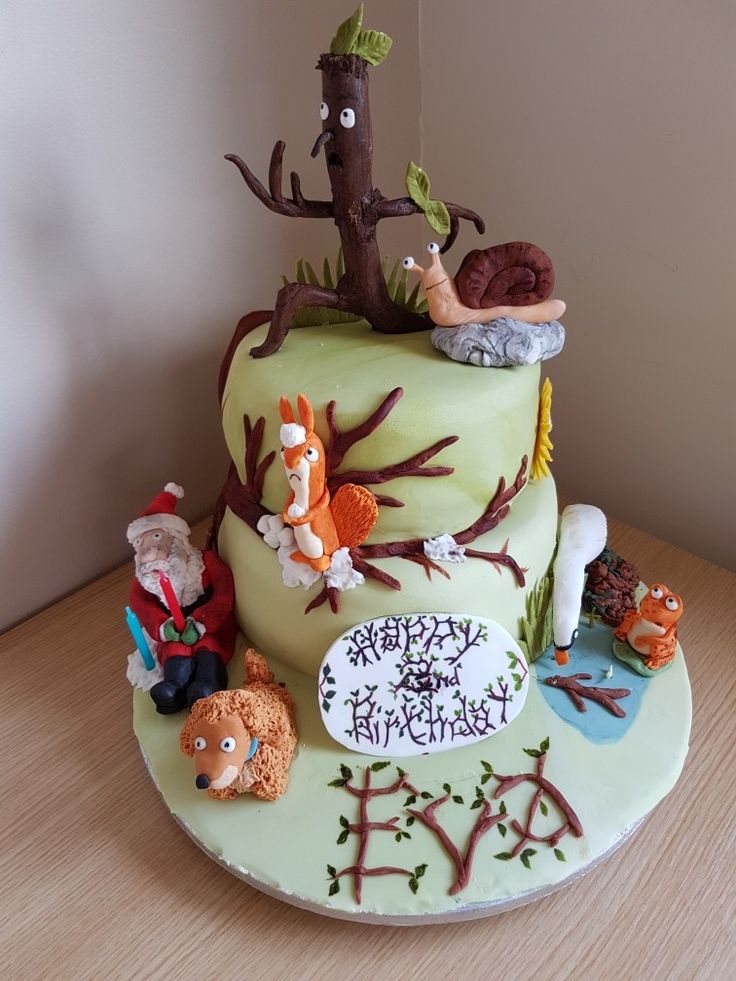 a birthday cake decorated with animals and trees