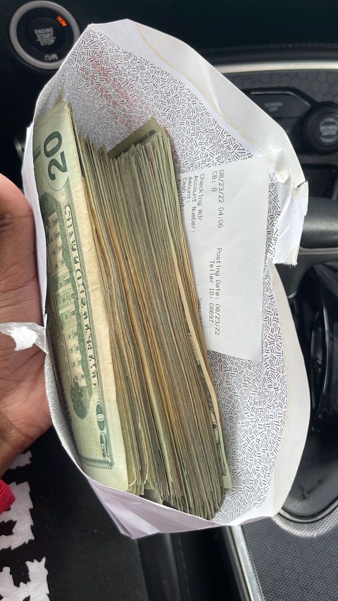 a person is holding money in their car