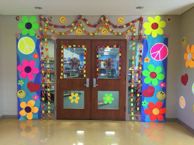 the front door to a school decorated with flowers and peace signs