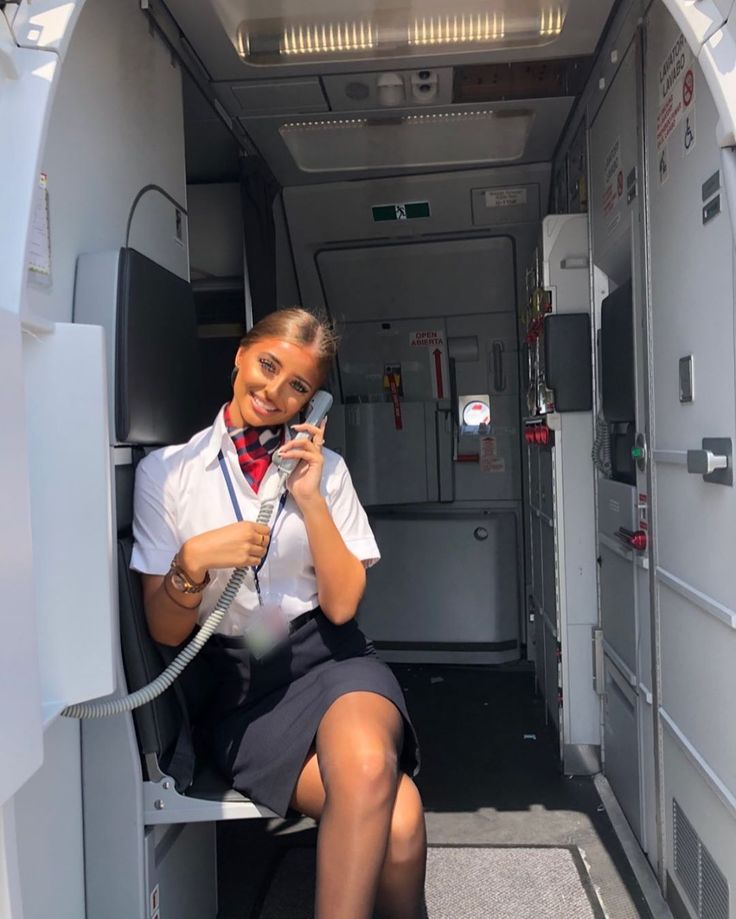 a woman sitting in the back of an airplane talking on a cell phone