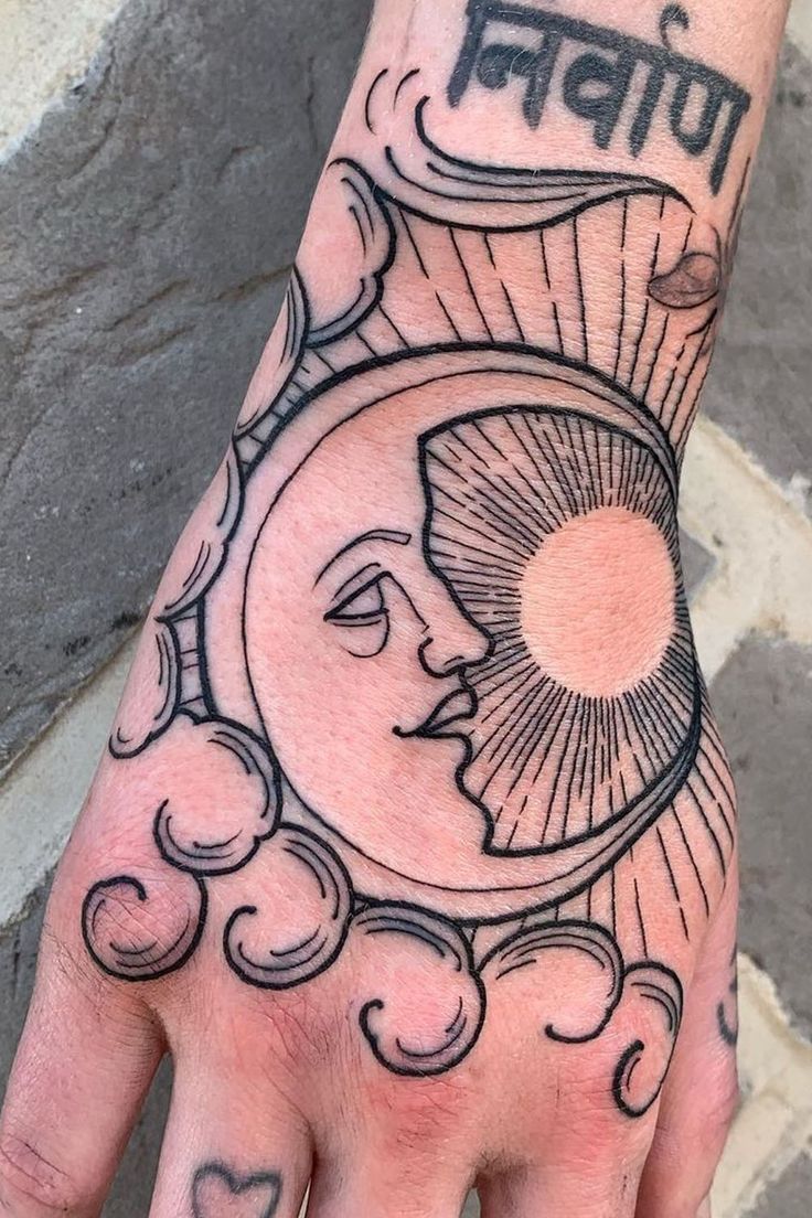 a person's hand with a sun and clouds tattoo on it