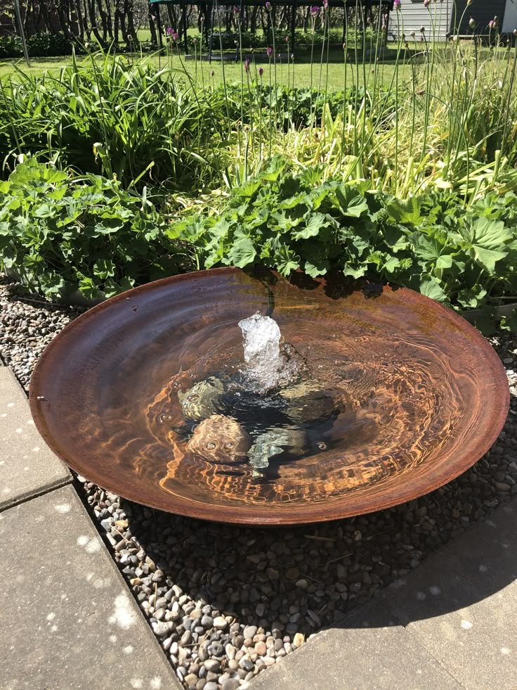 a bird bath sitting in the middle of a garden