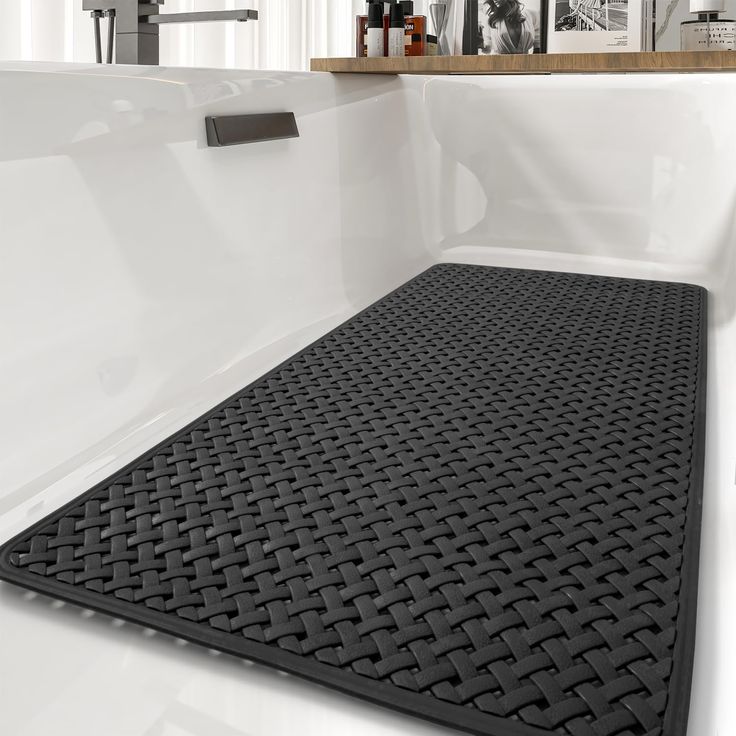 a bathroom with a black mat on the floor