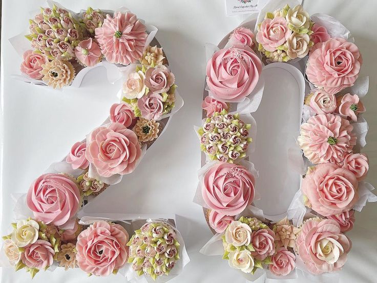 the number twenty two made out of pink and white flowers is displayed on a table