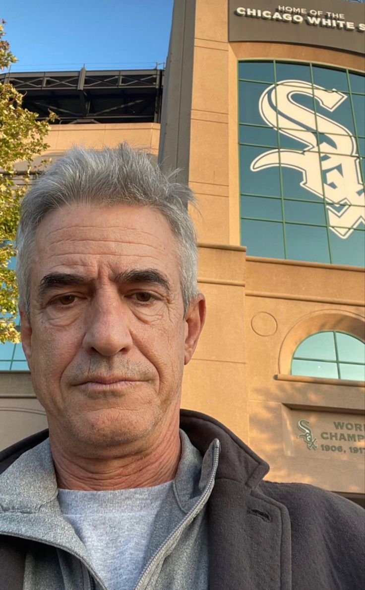 a man standing in front of a baseball stadium