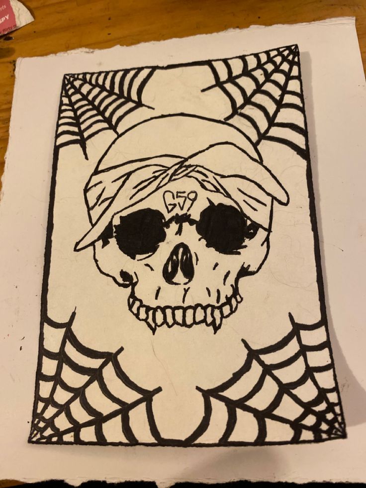 a drawing of a skull wearing sunglasses and a bandana on top of a piece of paper