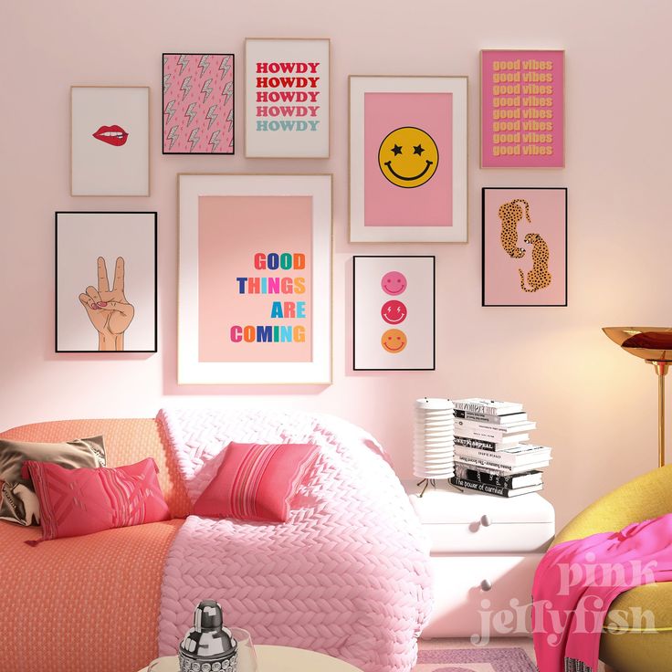 a bedroom with pink walls and pictures on the wall above the bed in front of it