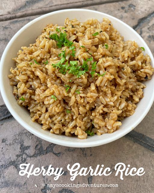 a white bowl filled with rice and garnished with parsley on the side