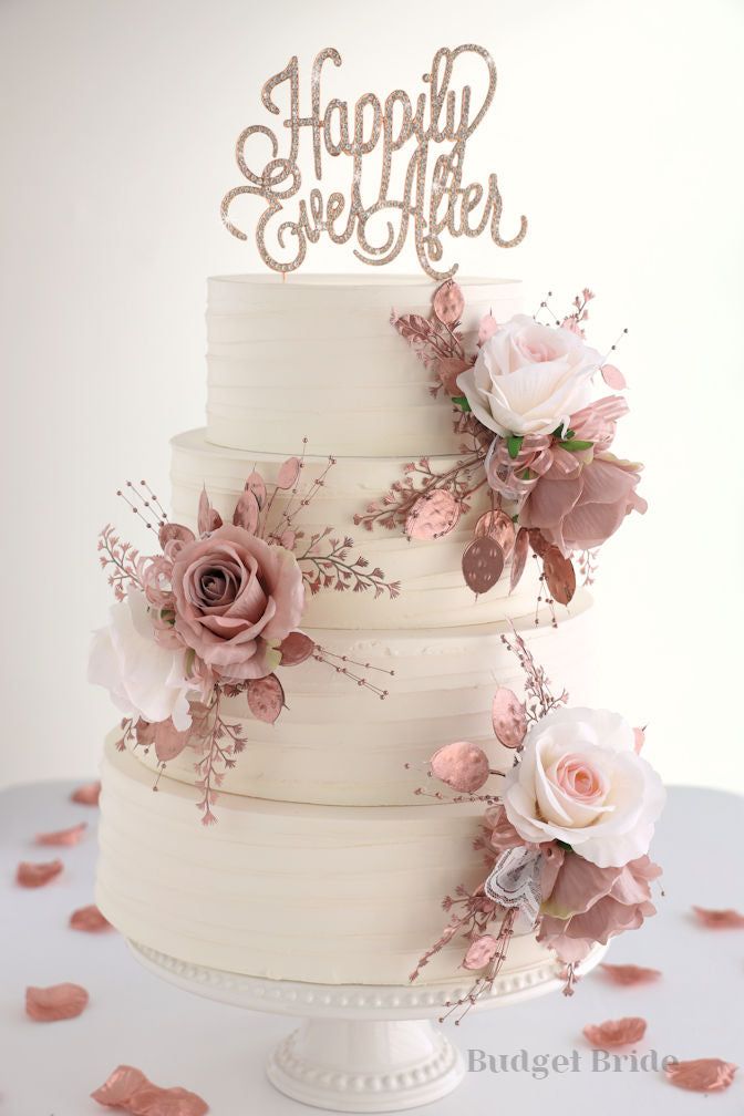 a three tiered cake with pink flowers and a happy ever after sign on top