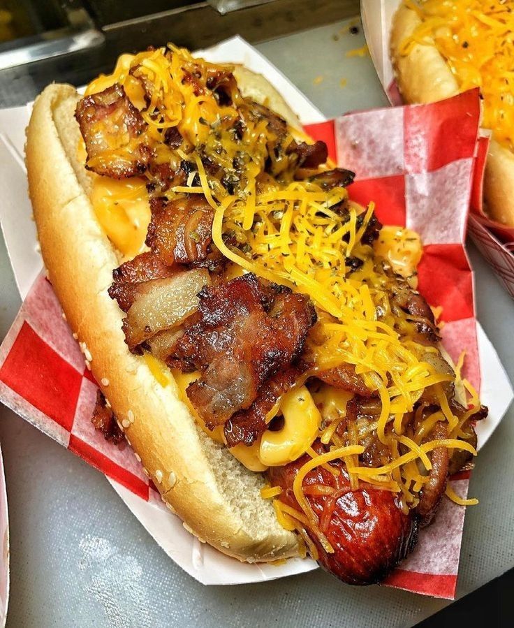 two hot dogs with cheese and bacon on them