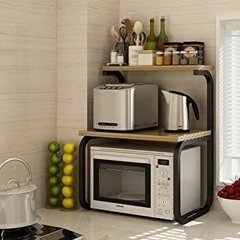 a microwave oven sitting on top of a counter next to a bowl of fruit