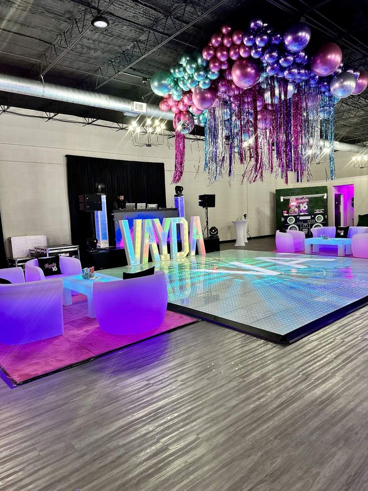 an indoor dance floor decorated with balloons and streamers