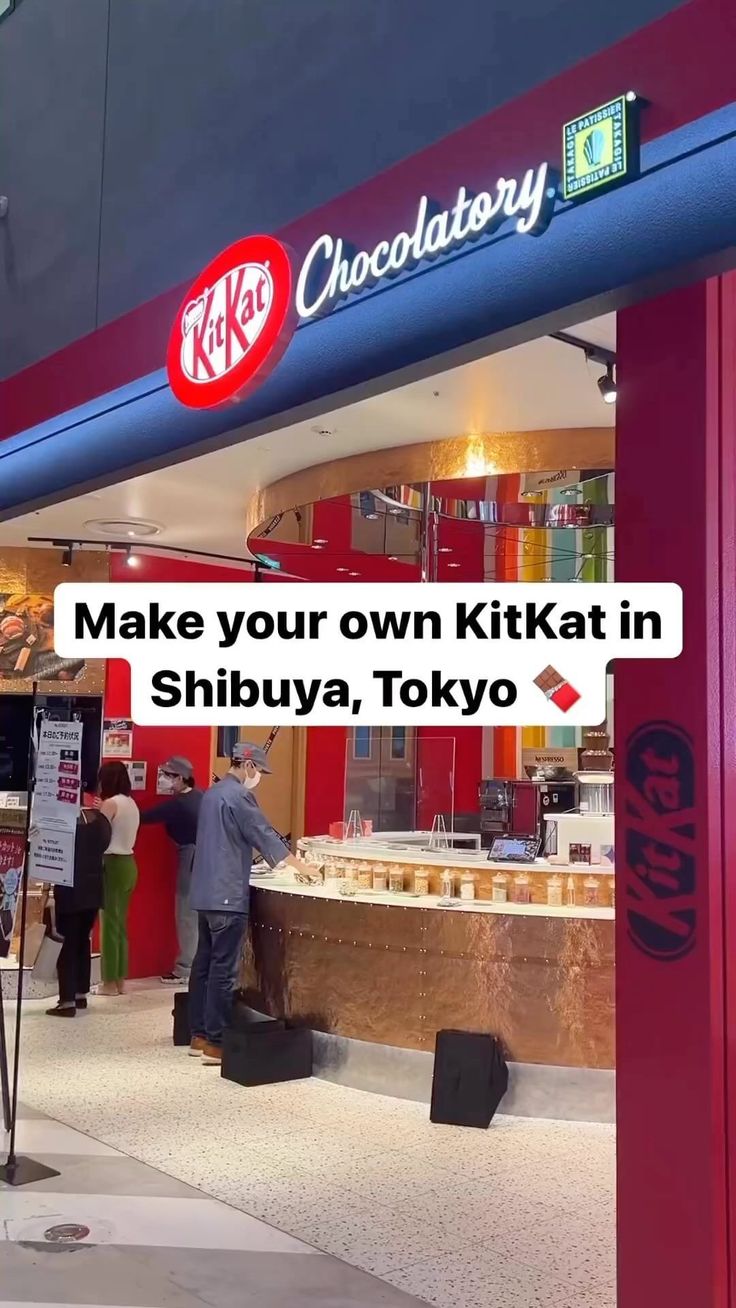 people are standing in front of a kiosk with the words make your own kitkatt in shibuya, tokyo