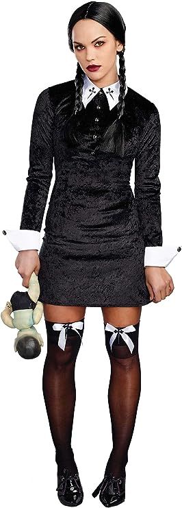 a woman in a black dress and stockings holding a teddy bear with her hands behind her back