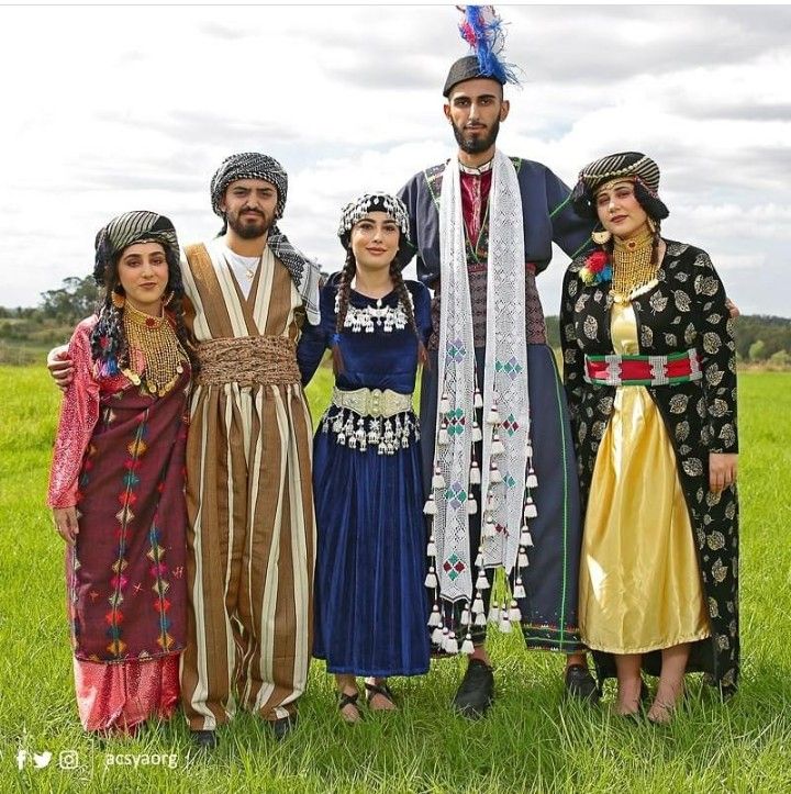 a group of people standing next to each other on top of a lush green field