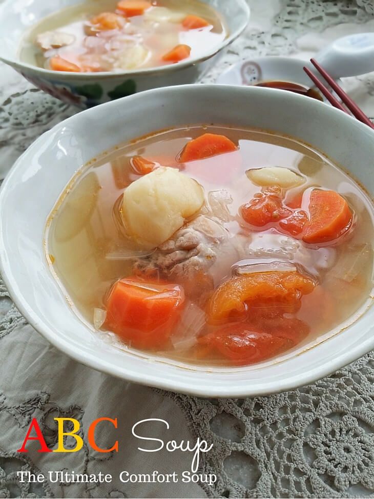 two bowls of soup with carrots, potatoes and meat on a lace tablecloth