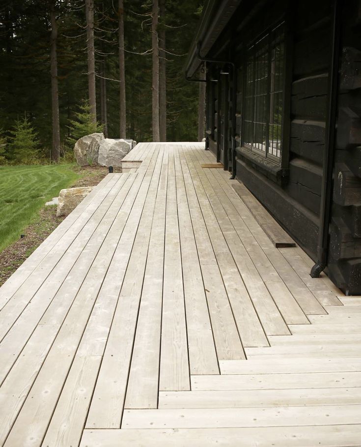 an empty wooden deck in front of a cabin