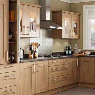 a kitchen filled with lots of wooden cabinets and counter top space next to a window