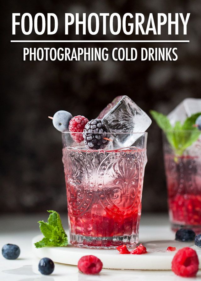 two glasses filled with raspberry and blueberries on top of a white table