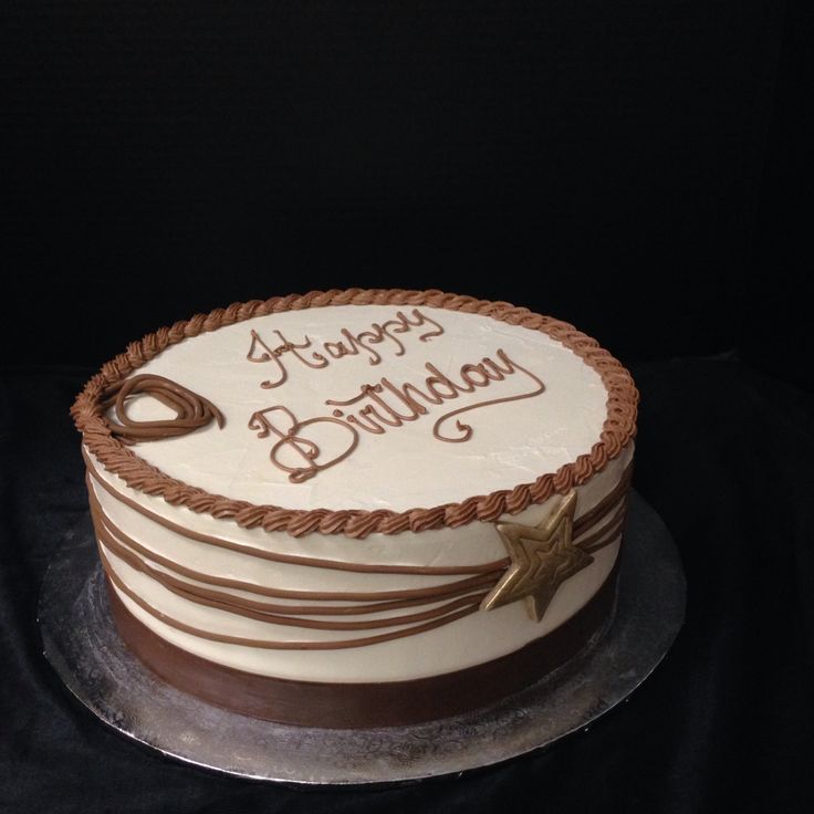 a white and brown birthday cake sitting on top of a table