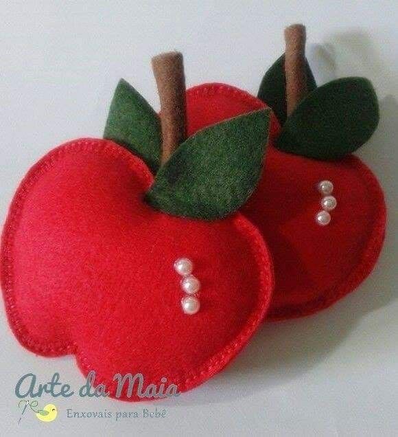 two red apples with green leaves and pearls