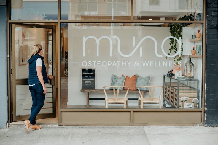 a woman standing in front of a store window