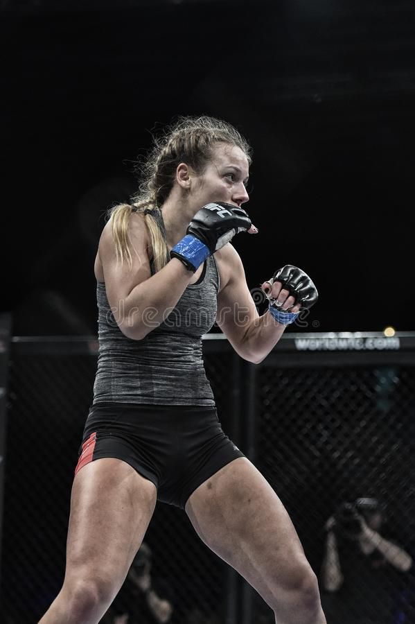 a woman in black shorts holding a boxing glove