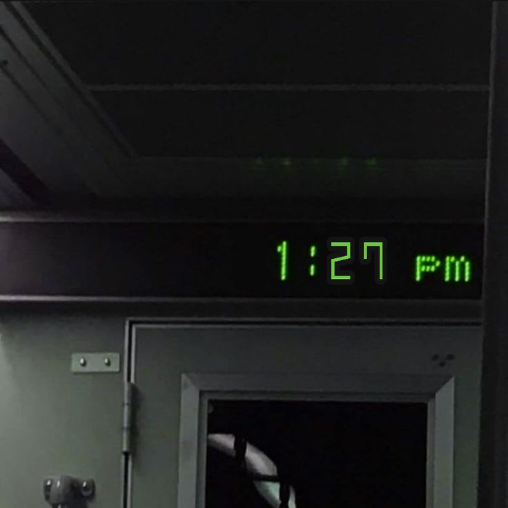 an exit sign with the time displayed on it's front door is lit up