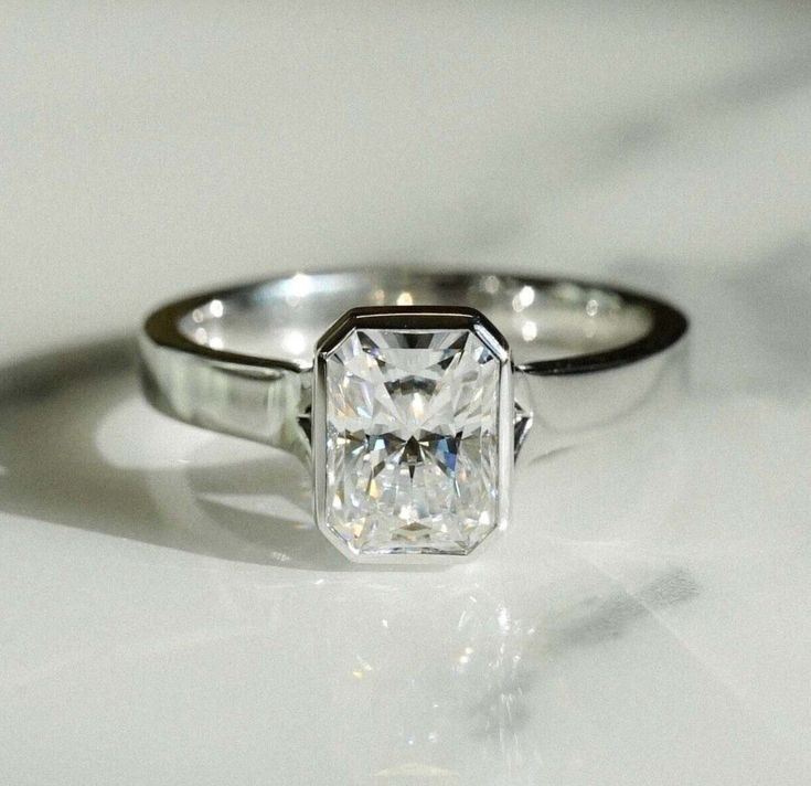 a white diamond ring sitting on top of a table