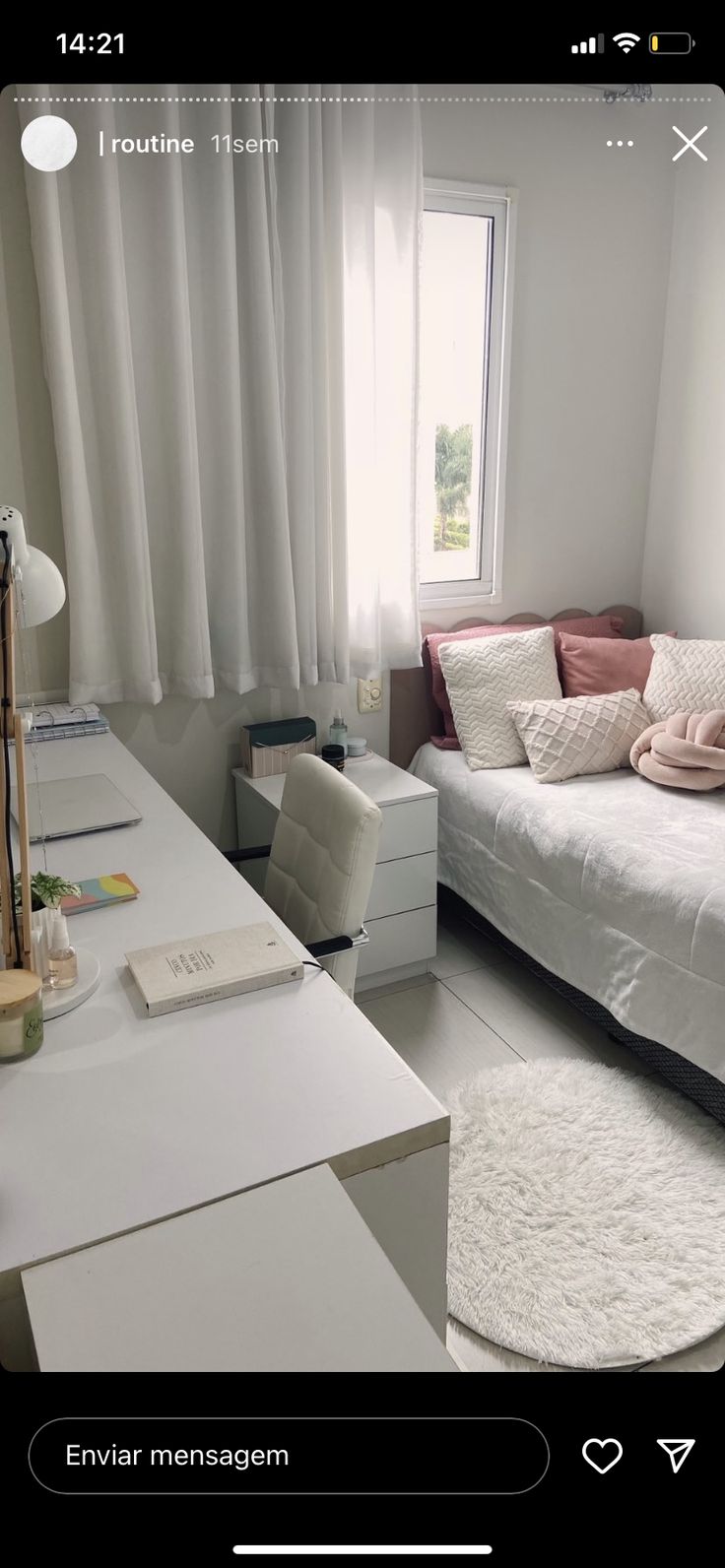 a white bed sitting next to a window in a bedroom