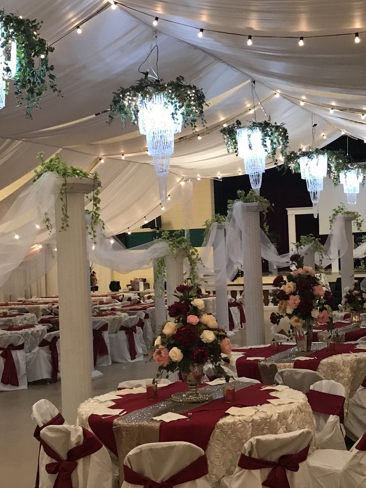 a banquet hall decorated with white and red linens