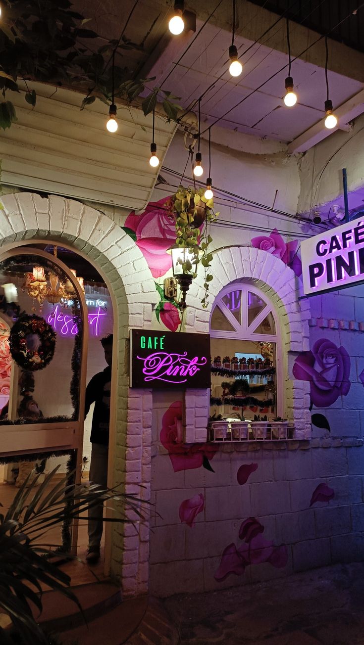 the interior of a cafe with pink and purple lights