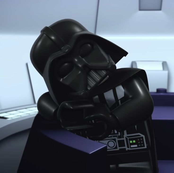 a lego darth vader head sitting on top of a desk