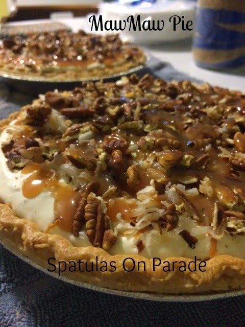 two pies sitting on top of a table covered in pecans and other toppings