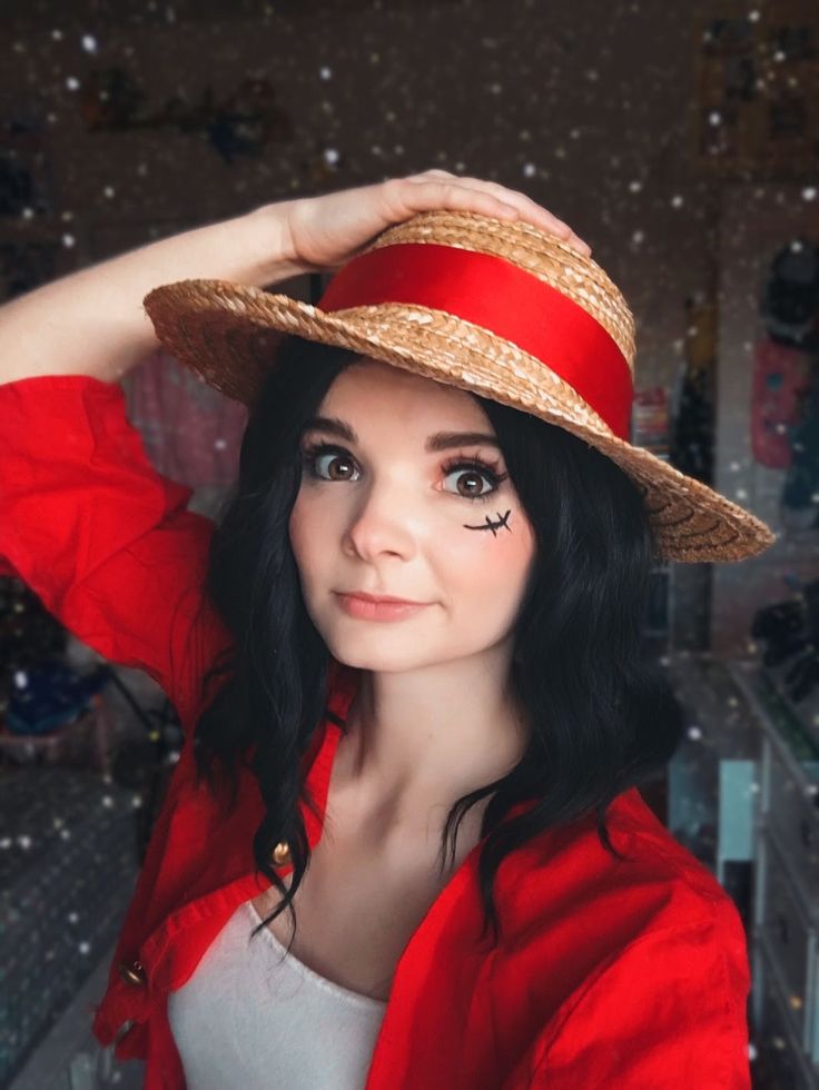 a woman in a red jacket and hat posing for the camera with her hand on her head