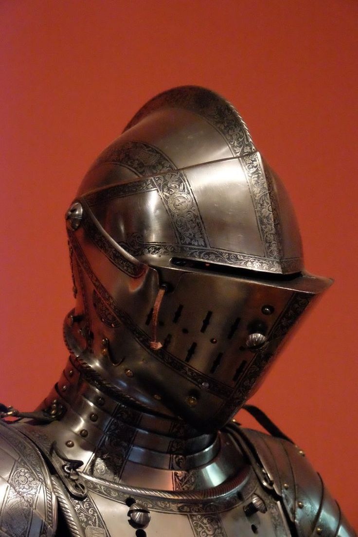 a knight's armor is displayed in front of a red wall with an orange background