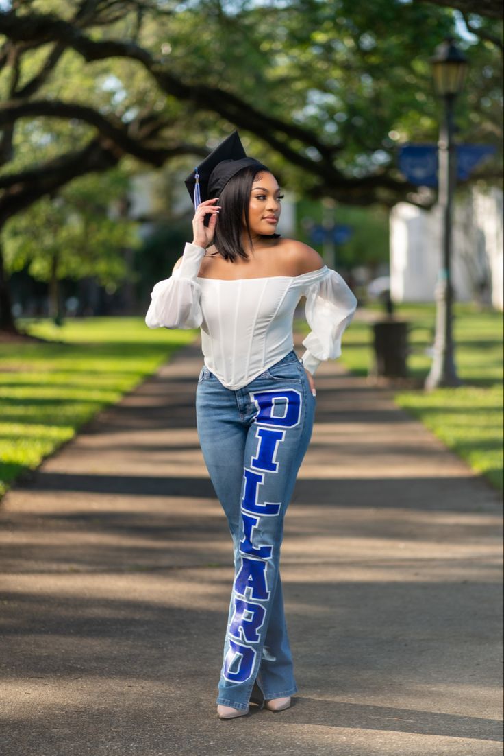 a woman is walking down the street with her hat in her hand and she's wearing blue jeans