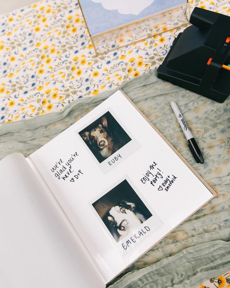 an open book sitting on top of a bed next to a pen