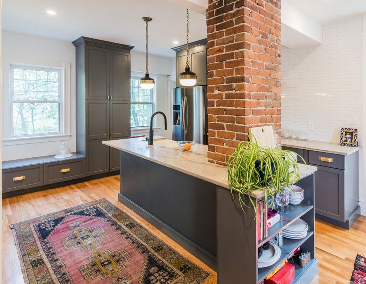 a kitchen with an island and brick wall