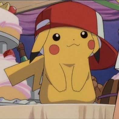 the pikachu is wearing a red hat and sitting in front of a table