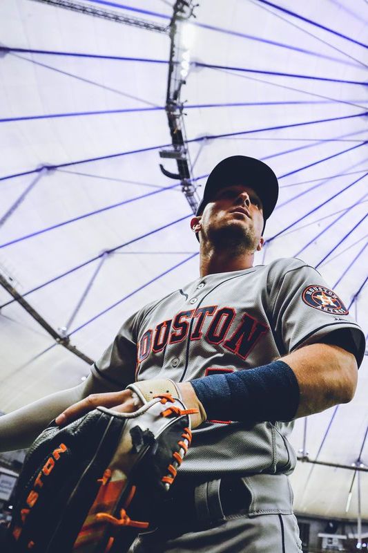 a baseball player is holding his glove in front of a ferris wheel