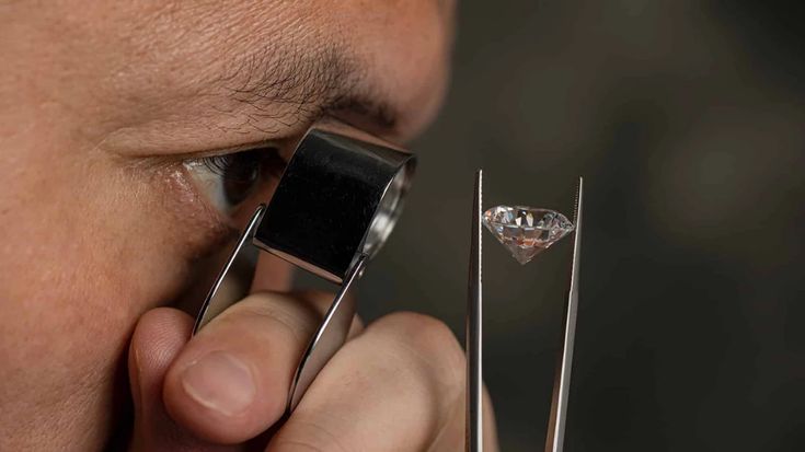 a close up of a person holding a pair of scissors in front of their face