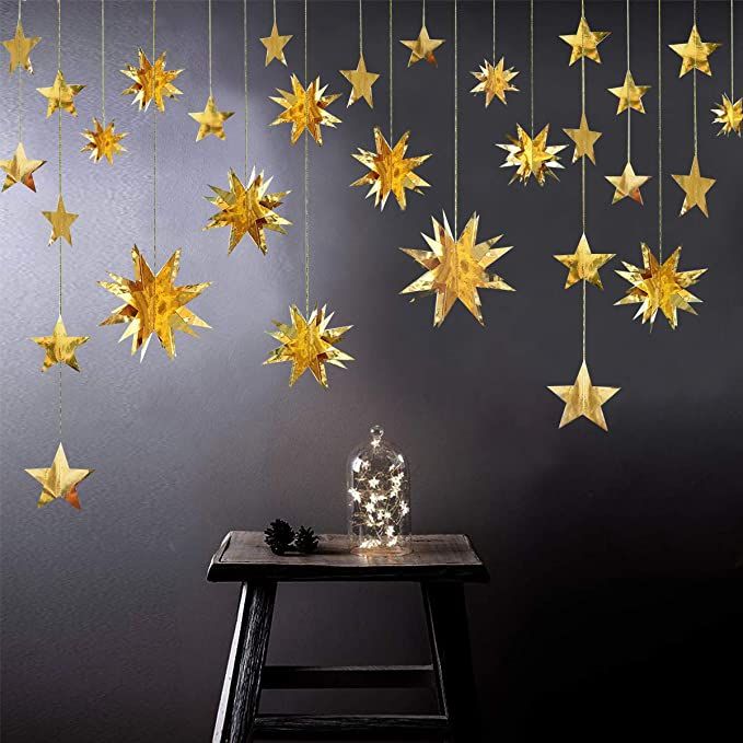 some gold stars hanging from the side of a wall next to a table and chair