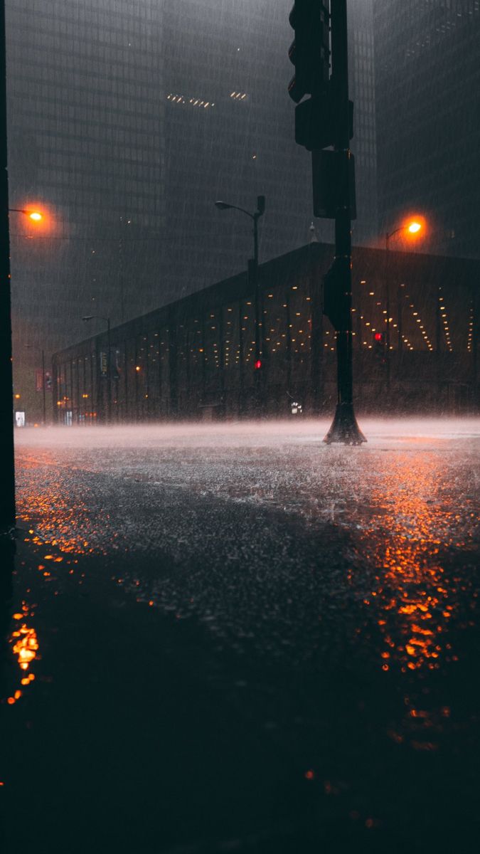 a city street is flooded with water and traffic lights are visible in the background at night